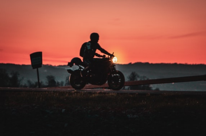 person riding bike with helmet with sunset in background